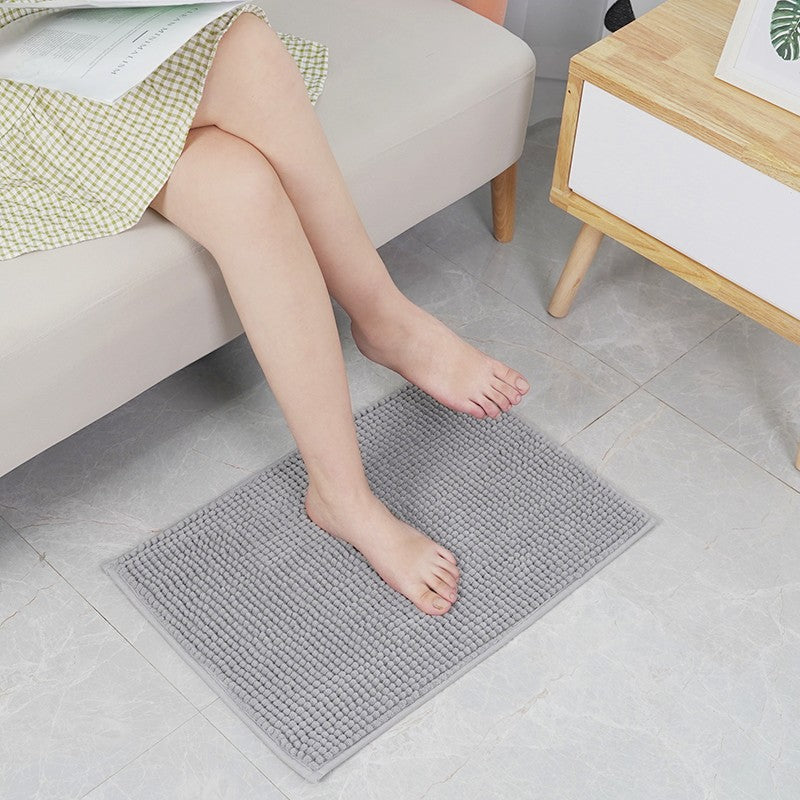 Person sitting on a gray textured Super Absorbent Door Mat in a living room setting.