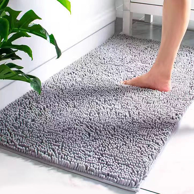 Gray textured Super Absorbent Door Mat on a white floor with a plant in the corner