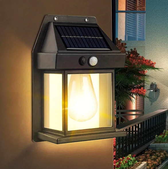 Solar-powered outdoor wall light fixture with warm glow on a wall.